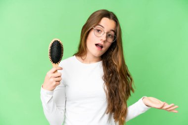 Teenager girl with hair comb over isolated chroma key background with shocked facial expression