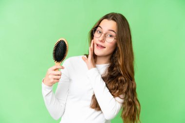 Teenager girl with hair comb over isolated chroma key background whispering something