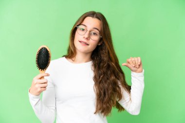 Teenager girl with hair comb over isolated chroma key background proud and self-satisfied