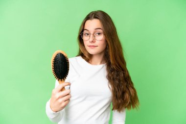 Teenager girl with hair comb over isolated chroma key background with happy expression