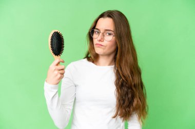 Teenager girl with hair comb over isolated chroma key background with sad expression