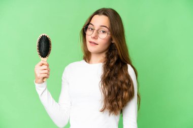 Teenager girl with hair comb over isolated chroma key background smiling a lot