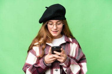 Teenager girl over isolated chroma key background sending a message or email with the mobile