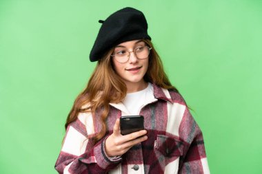 Teenager girl over isolated chroma key background sending a message or email with the mobile