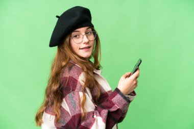 Teenager girl over isolated chroma key background sending a message or email with the mobile