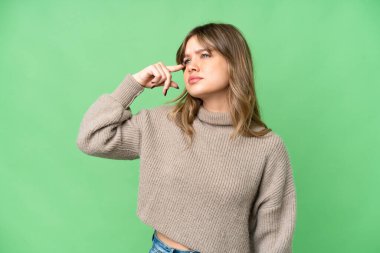 İzole edilmiş krom anahtar geçmişi olan genç bir kız deliliğin jestini yapıyor. Parmağını kafaya koyuyor.