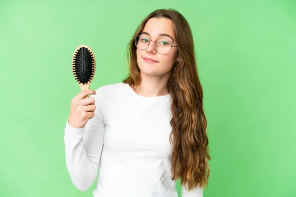 Teenager girl with hair comb over isolated chroma key background smiling a lot