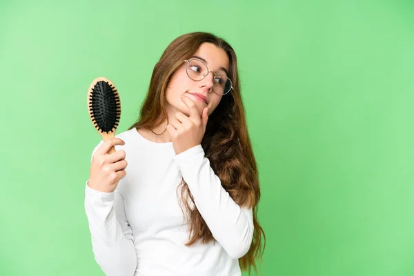 Teenager girl with hair comb over isolated chroma key background thinking an idea and looking side