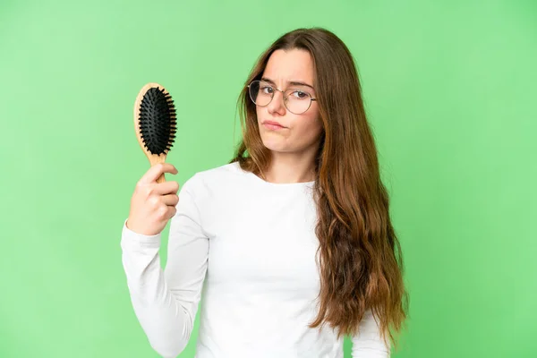 Teenager girl with hair comb over isolated chroma key background with sad expression