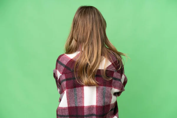 年轻女孩背对着孤立的色斑背景 — 图库照片