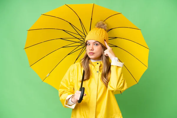 若いです女の子とともにレインプルーフコートと傘上の隔離されたクロマキー背景考え方 — ストック写真