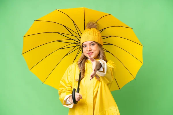 若いです女の子とともにレインプルーフコートと傘上の隔離されたクロマキー背景シャーク手のために良い取引を閉じます — ストック写真