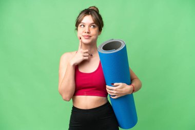 Genç sporcu kız yoga derslerine giderken elinde bir paspas tutarak izole edilmiş krom anahtar arkaplanı araştırırken aklına bir fikir geldi.