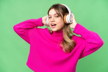 Genç kız izole edilmiş krom anahtar arka planda müzik dinliyor