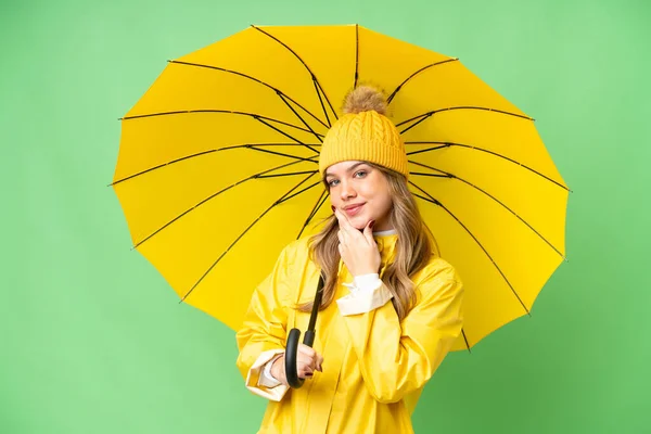 若いです女の子とともにレインプルーフコートと傘上の隔離されたクロマキー背景幸せと笑顔 — ストック写真