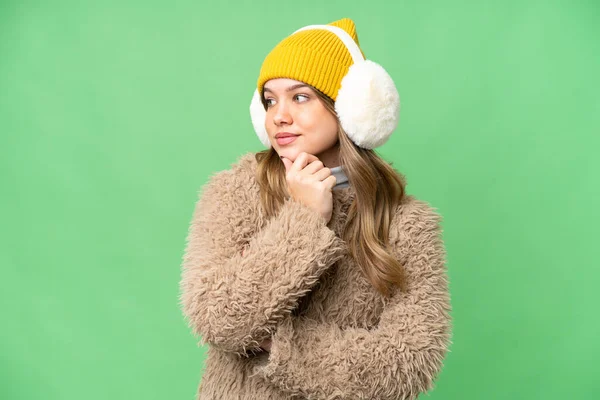 年轻姑娘披着冬衣 凝视着周围孤立的彩色关键背景 — 图库照片