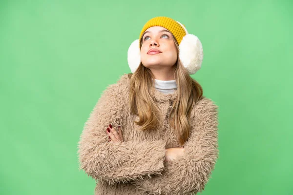 年轻姑娘披着冬衣 面带微笑地抬起头 凝视着孤立的彩色关键背景 — 图库照片