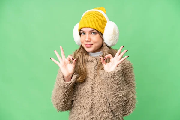 Νεαρό Κορίτσι Φορώντας Muffs Χειμώνα Πάνω Από Απομονωμένο Φόντο Chroma — Φωτογραφία Αρχείου