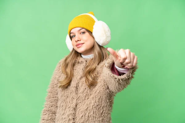 年轻姑娘戴着冬衣 戴在孤立的彩色关键背景上 竖起大拇指 — 图库照片