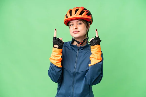 stock image Young cyclist girl over isolated chroma key background pointing up a great idea