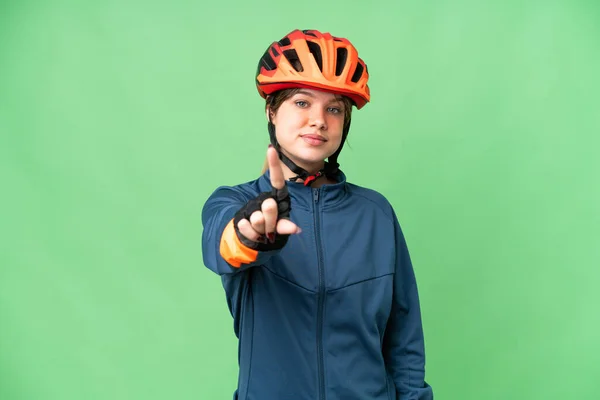 若いですサイクリスト女の子上の隔離されたクロマキー背景ショーと持ち上げる指 — ストック写真