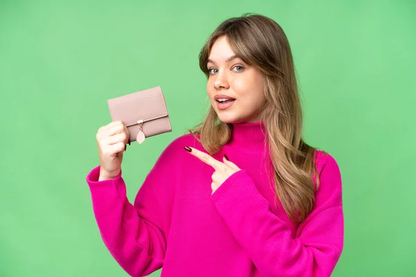 孤立したクロマキーの背景に財布を保持し それを指す若い女の子 — ストック写真