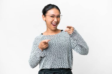 Genç Uruguaylı kadın izole edilmiş beyaz arka planda ön tarafı işaret ediyor ve gülümsüyor.