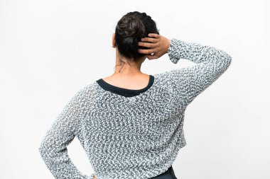 Young Uruguayan woman over isolated white background in back position and thinking