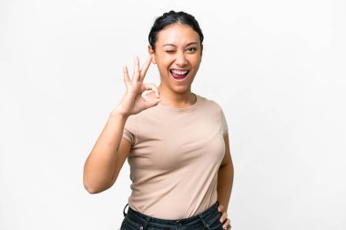 Genç Uruguaylı kadın izole edilmiş beyaz arka planda parmaklarıyla tamam işareti gösteriyor.