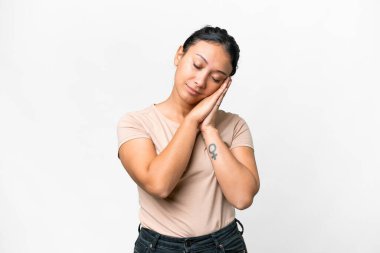 Genç Uruguaylı kadın izole edilmiş beyaz arkaplan üzerinde uyku jesti yapıyor.