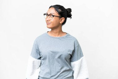 Young Uruguayan woman over isolated white background looking to the side and smiling