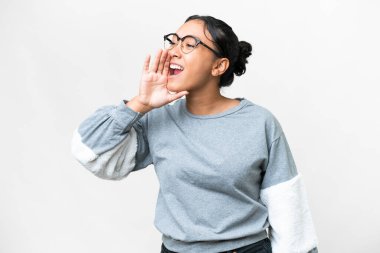 Young Uruguayan woman over isolated white background shouting with mouth wide open to the side
