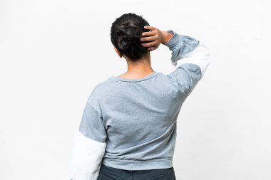 Young Uruguayan woman over isolated white background in back position and thinking