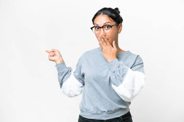 Young Uruguayan woman over isolated white background with surprise expression while pointing side