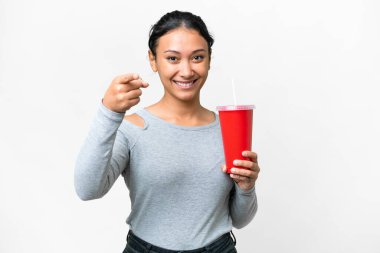 Genç Uruguaylı kadın izole edilmiş beyaz arka plan üzerinde soda tutuyor. Kendine güvenen bir ifadeyle seni işaret ediyor.