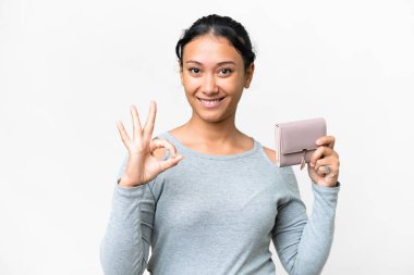 Young Uruguayan woman holding a wallet over isolated white background showing ok sign with fingers