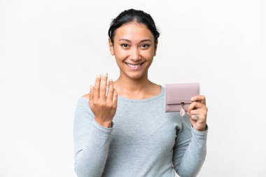 Young Uruguayan woman holding a wallet over isolated white background inviting to come with hand. Happy that you came