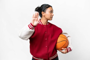 Young Uruguayan woman playing basketball over isolated wall  over isolated white background making stop gesture and disappointed