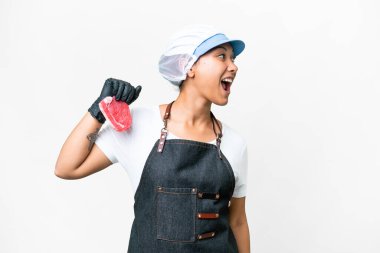 Butcher woman wearing an apron and serving fresh cut meat over isolated white background laughing in lateral position
