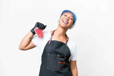 Butcher woman wearing an apron and serving fresh cut meat over isolated white background laughing