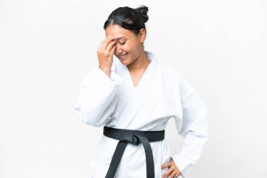 Young Uruguayan woman doing karate over isolated white background laughing