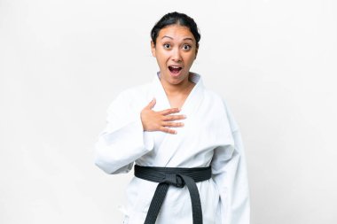 Young Uruguayan woman doing karate over isolated white background surprised and shocked while looking right