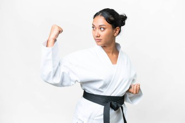 Young Uruguayan woman over isolated white background doing karate