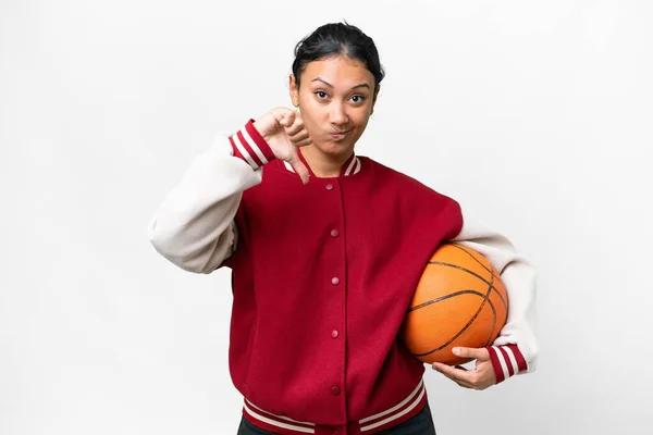 Young Uruguayan woman playing basketball over isolated wall  over isolated white background showing thumb down with negative expression