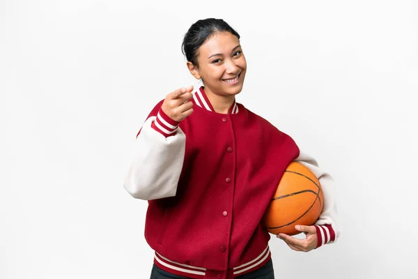 若いですウルグアイ人女性プレイバスケットボール上の隔離された白い背景ポインティング上のフロントで幸せな式 — ストック写真