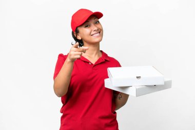 Pizza dağıtan kadın iş üniformalı izole edilmiş beyaz arka planda pizza kutuları alıyor ve mutlu bir ifadeyle önünü gösteriyor.