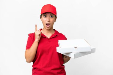 Pizza teslimatçısı kadın, iş üniformasıyla izole edilmiş beyaz arka planda pizza kutularını topluyor. Çözümün ne olduğunu anlamak için parmağını kaldırıyor.
