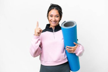 Genç sporcu kadın yoga derslerine giderken elinde paspas tutarak harika bir fikre işaret ediyor.