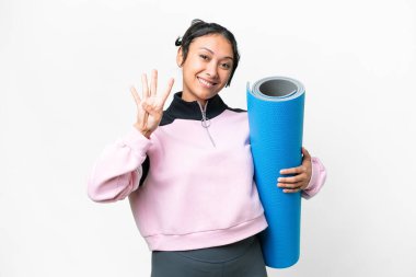 Genç sporcu kadın yoga derslerine giderken izole edilmiş beyaz arka plan üzerinde minder tutuyor ve parmaklarıyla dörde kadar sayıyor.