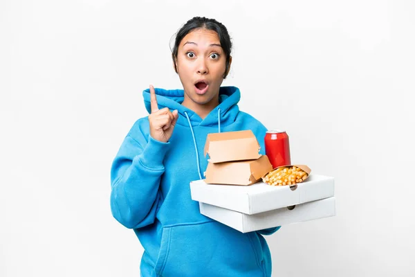Young Uruguayan Woman Holding Pizzas Burgers Isolated White Background Intending — стоковое фото
